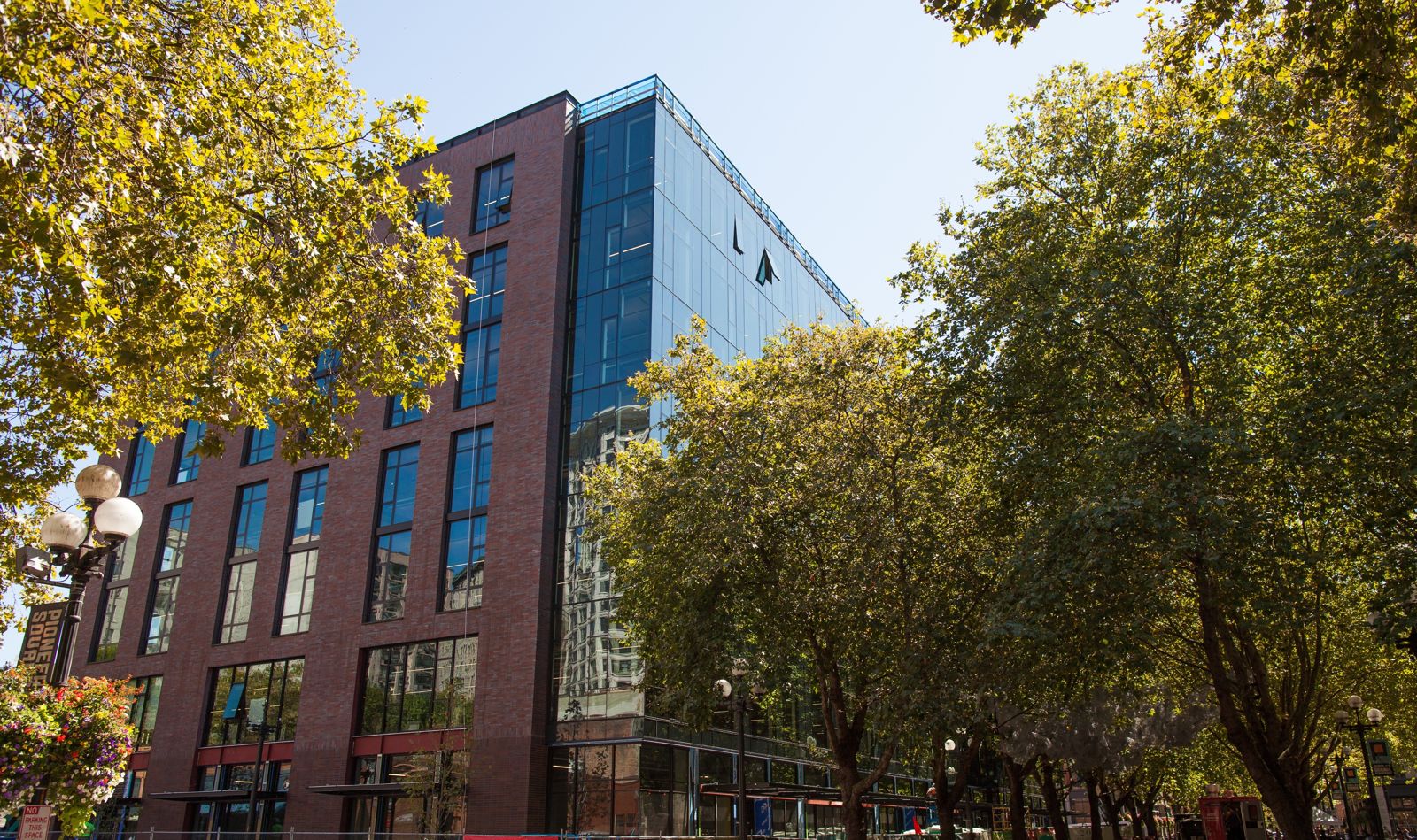 Brick and glass building behind autumn trees