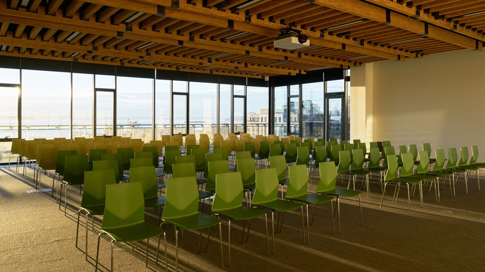 Weyerhaeuser: Event room with rows of green chairs and glass walls