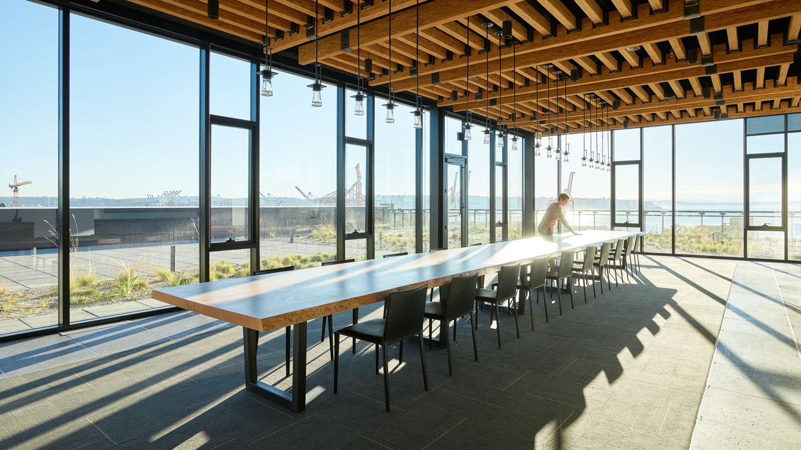 Weyerhaeuser: Long table in a glass-walled rooftop room with a timber ceiling