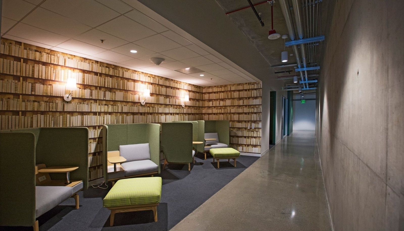 Workday: Quiet booths along a wall of book-like panels