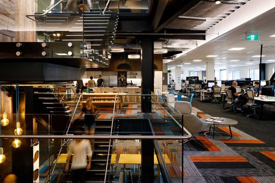 Xero: Looking across the open stair void to an office floor with desks and lounge seating