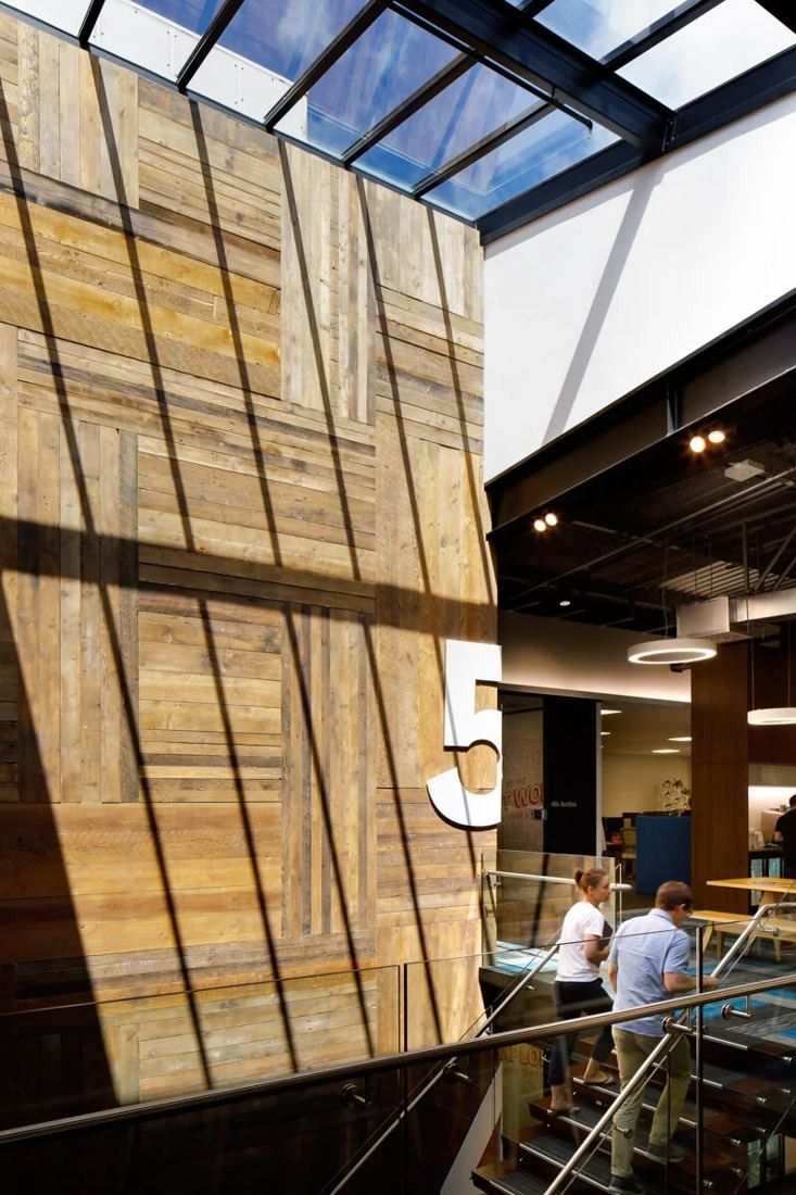 Xero: Tall reclaimed timber wall with a large number 5 under a glazed roof