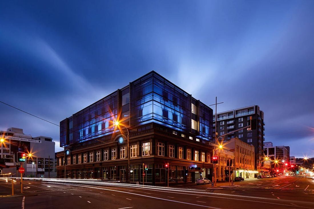 Xero: The heritage facade and dark upper floors lit in blue at dusk, with light trails on the street