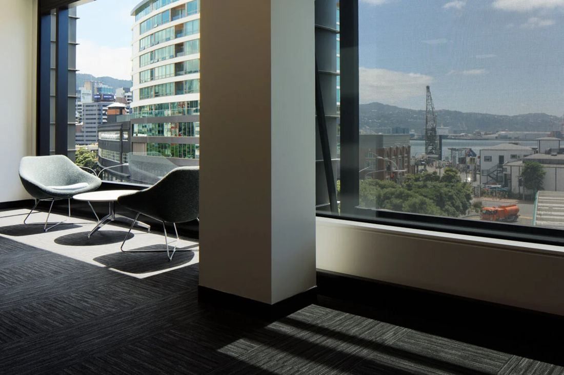 Xero: Two lounge chairs by a tall window overlooking city buildings and the harbour