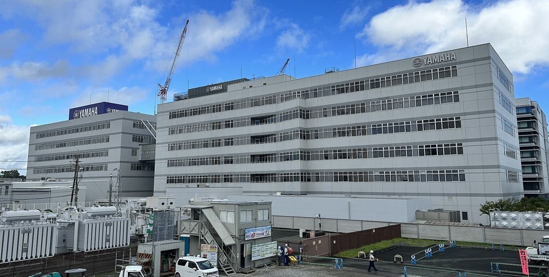 Yamaha: White multi-story buildings with a construction crane rising behind them