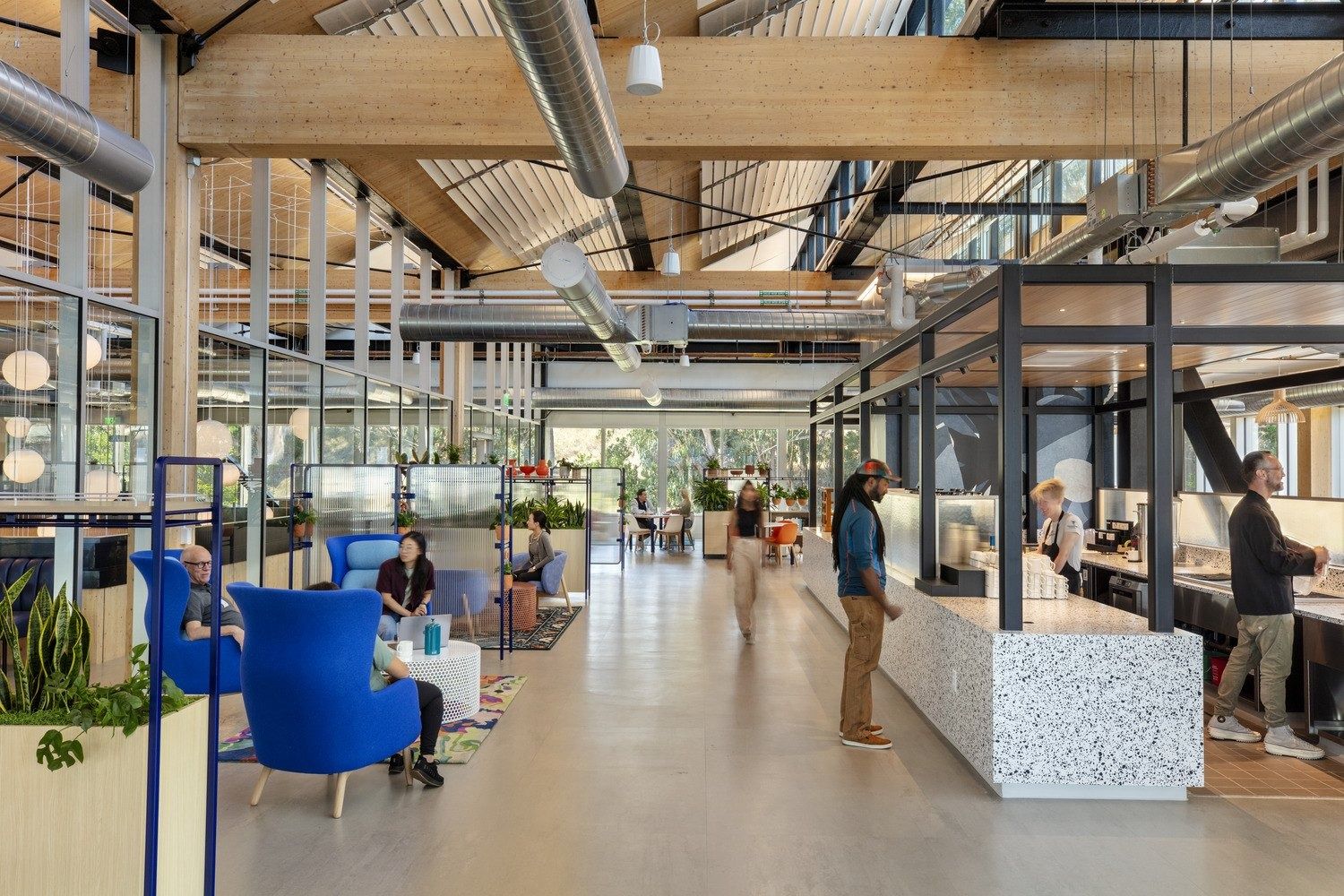 YouTube: Long timber-framed hall with blue armchairs and a terrazzo coffee counter