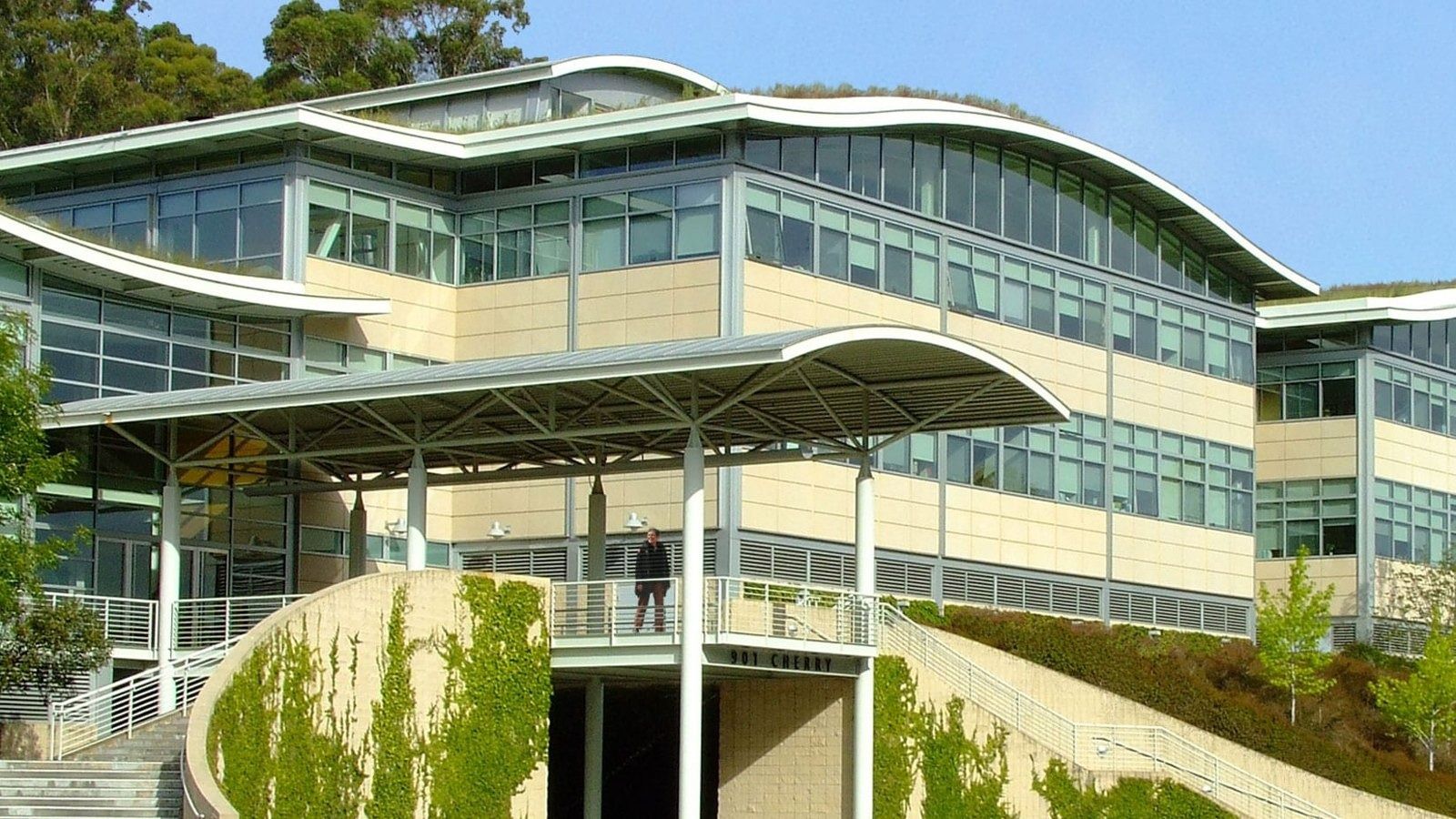YouTube: Office building with layered curved roofs, a glass entrance canopy and planted slopes
