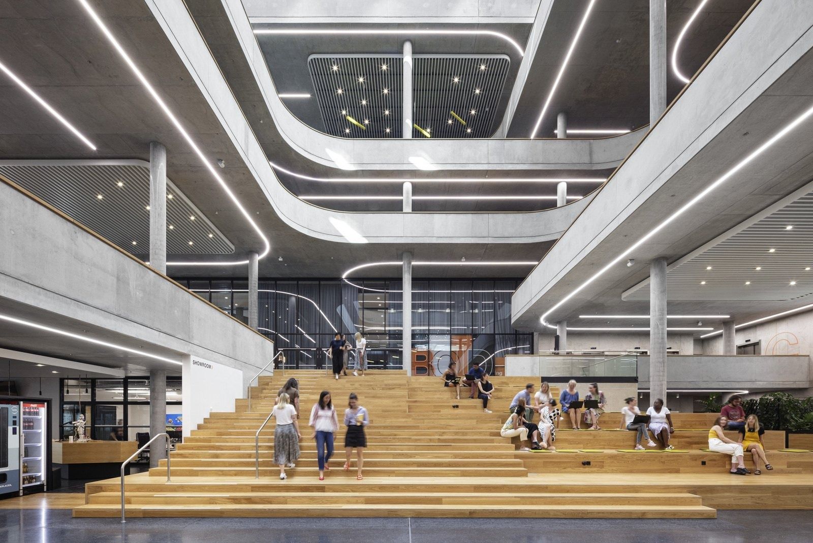Zalando: Atrium with wide wooden bleacher steps beneath curved concrete balconies and linear lights