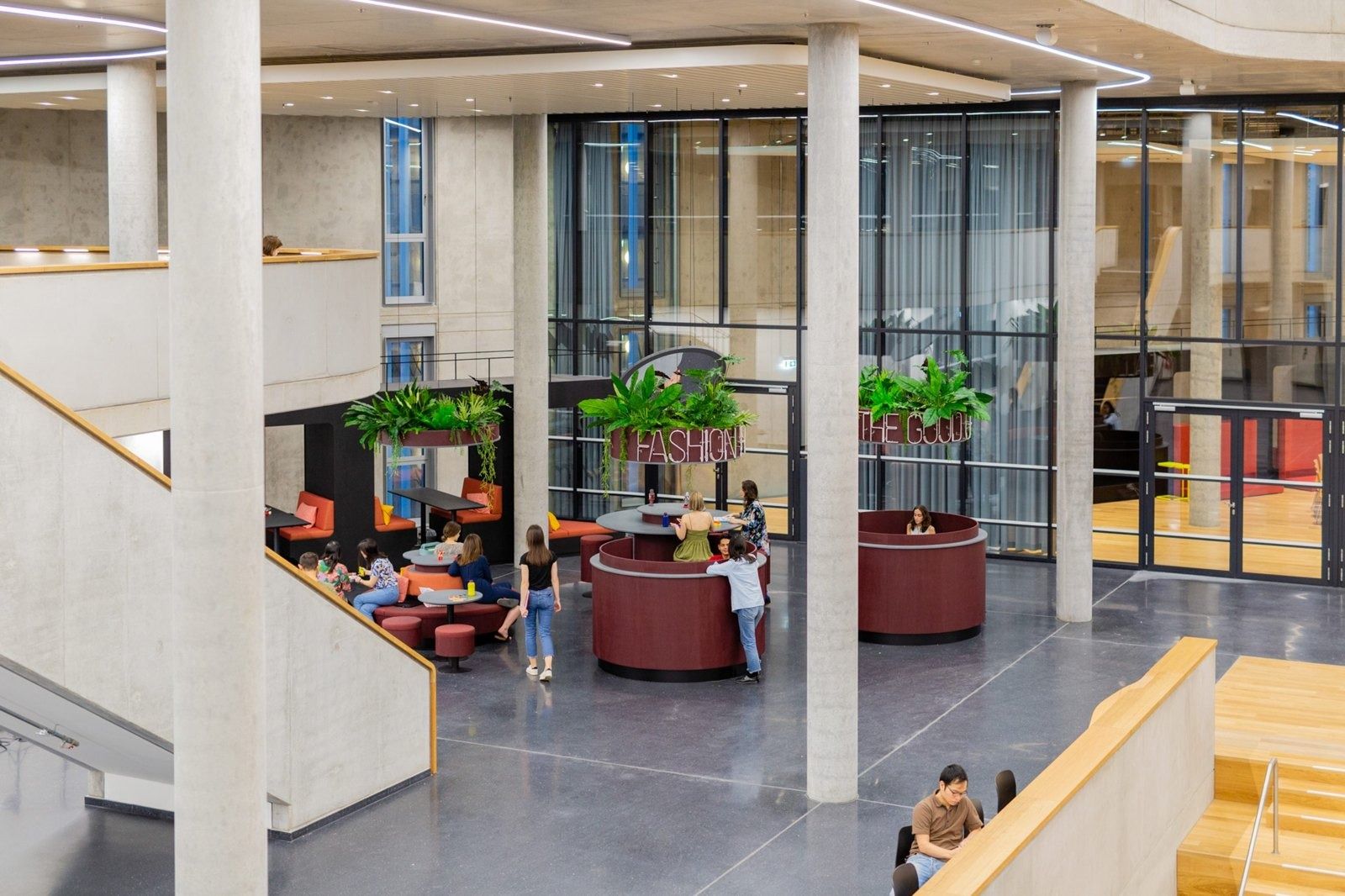 Zalando: Double-height space with round red seating, plants and glass partitions