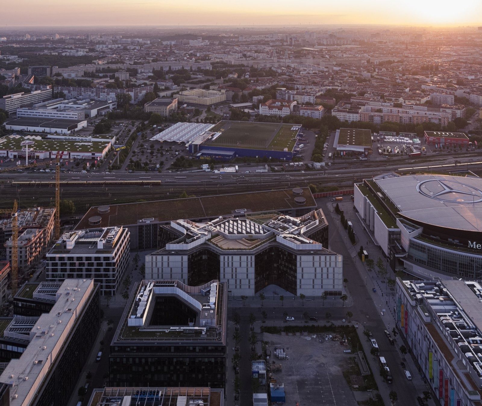 Zalando: Elevated city view at dusk with the zigzag building beside an arena