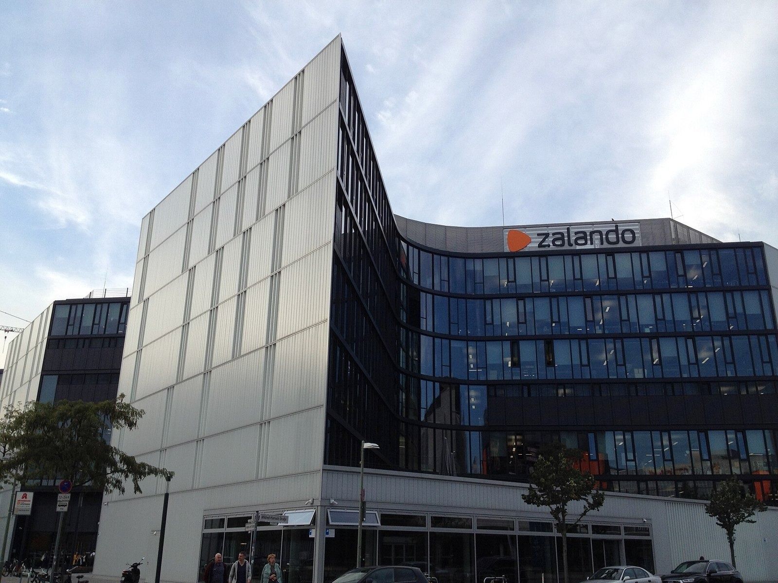 Zalando: Office building with a pale panelled corner and dark glass wing bearing the Zalando sign