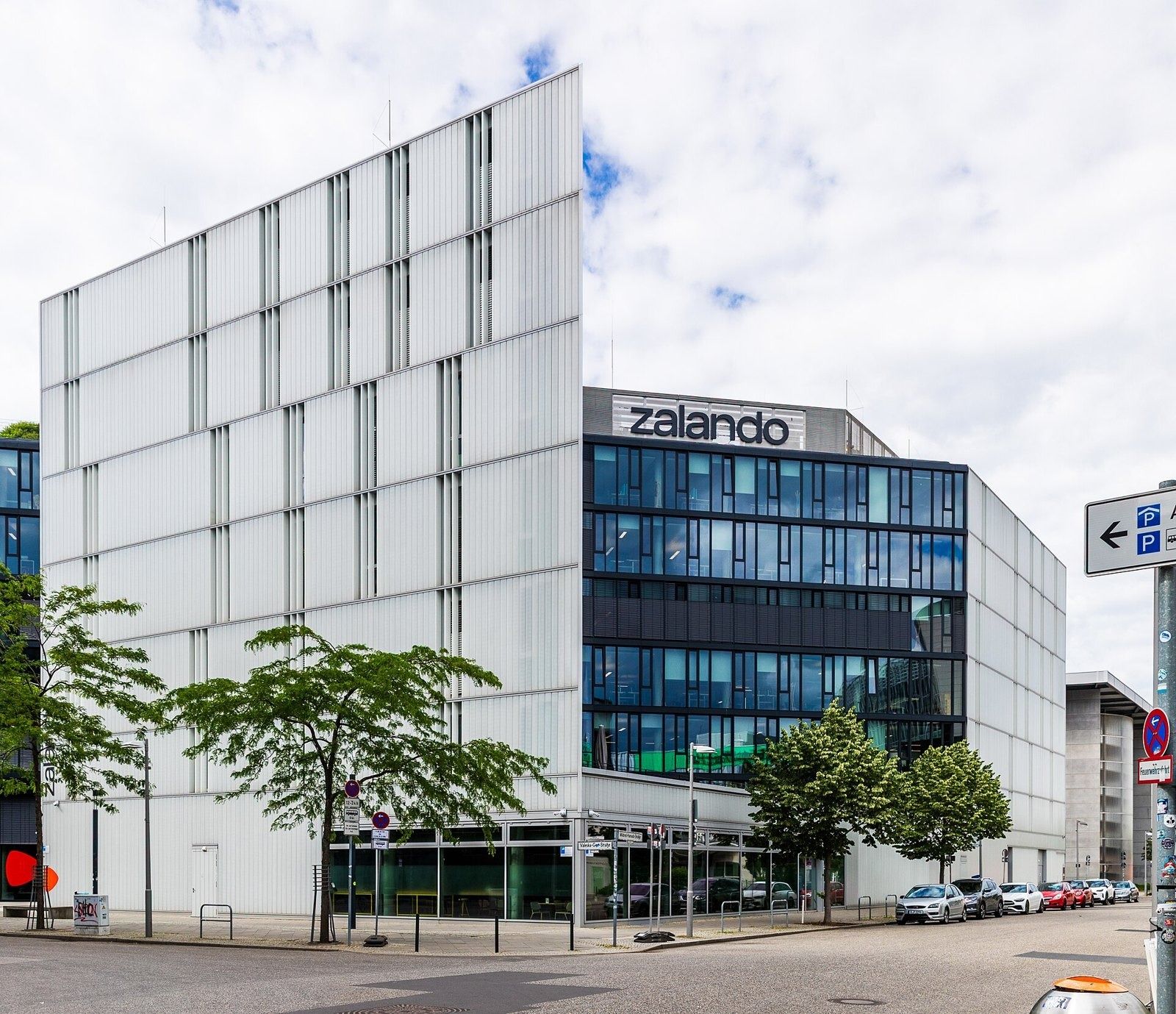 Zalando: Pale panelled facade and glass wing on a street corner with trees