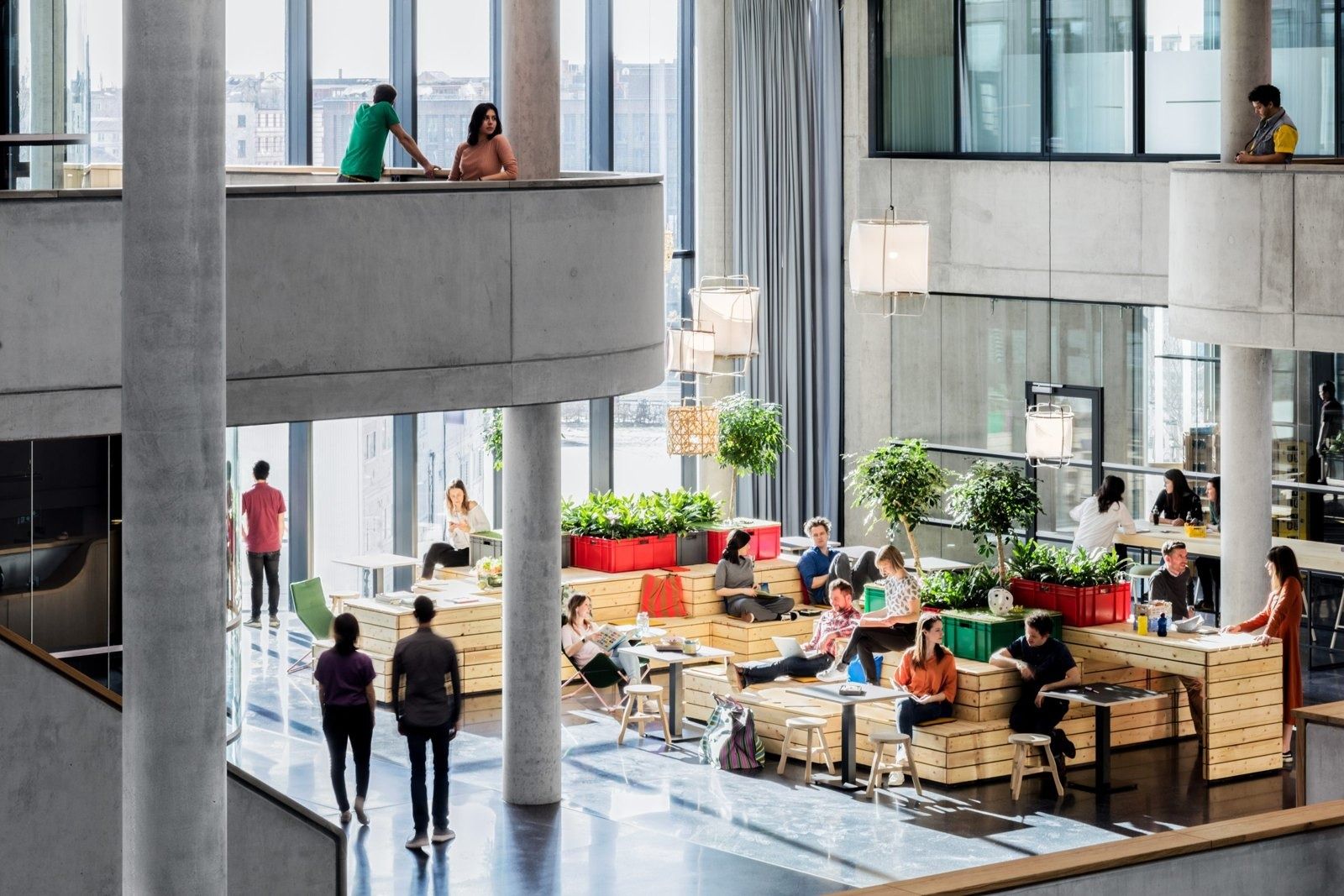 Zalando: Wooden platform seating with plants beside concrete columns and a curved balcony