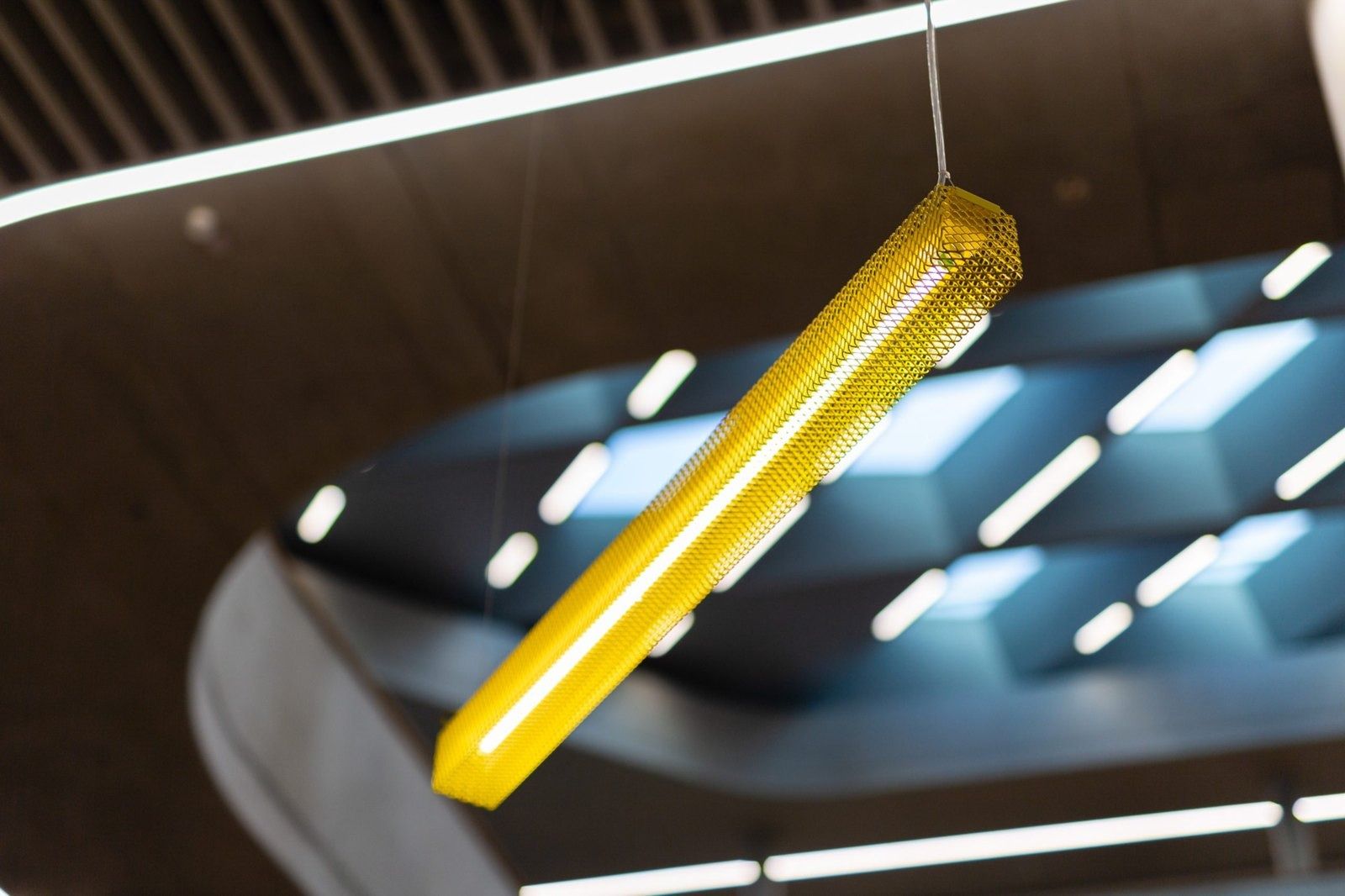 Zalando: Yellow perforated pendant light against a dark ceiling