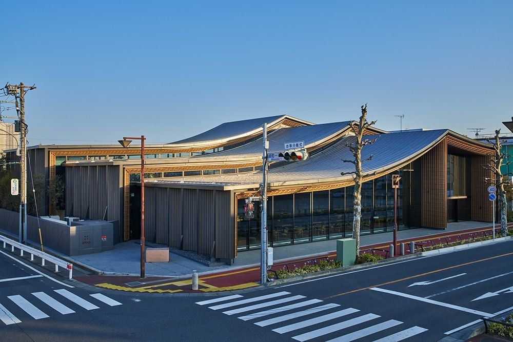ZOZO: Corner view of a building with wavy roofs beside a pedestrian crossing