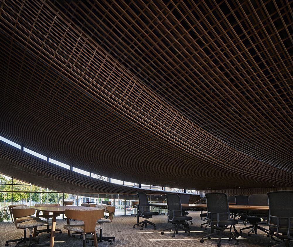 ZOZO: Low curve of a wooden lattice ceiling above desks and chairs