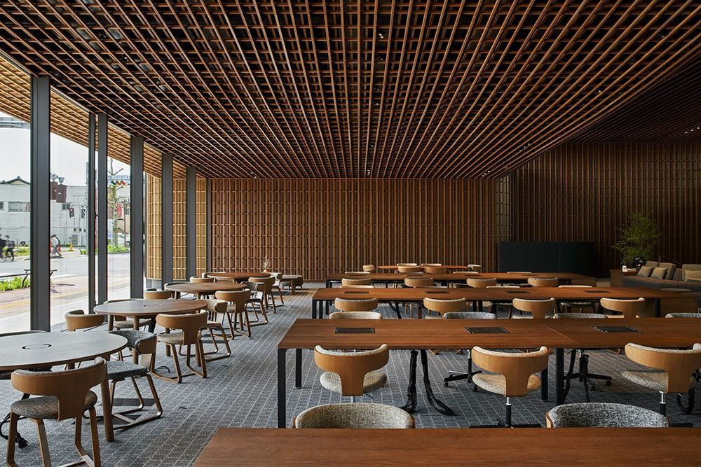 ZOZO: Rows of wooden tables beside a glass wall onto the street
