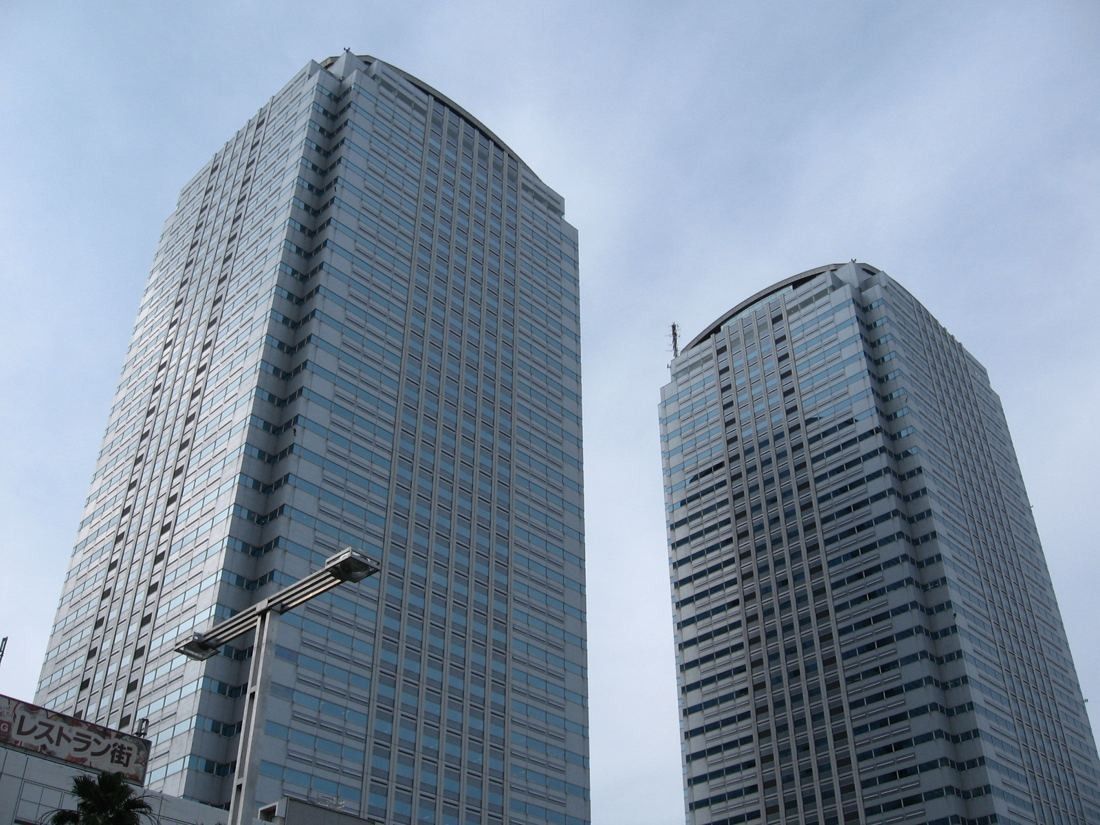 Two tall rounded glass office towers seen from below