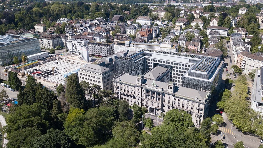Zurich Insurance Group: Aerial view of a large block of historic and modern buildings around courtyards, surrounded by trees and city streets