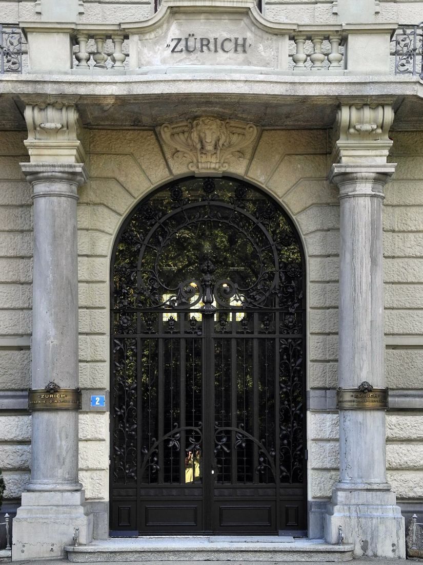 Zurich Insurance Group: Arched wrought-iron entrance door between stone columns with the word ZÜRICH above