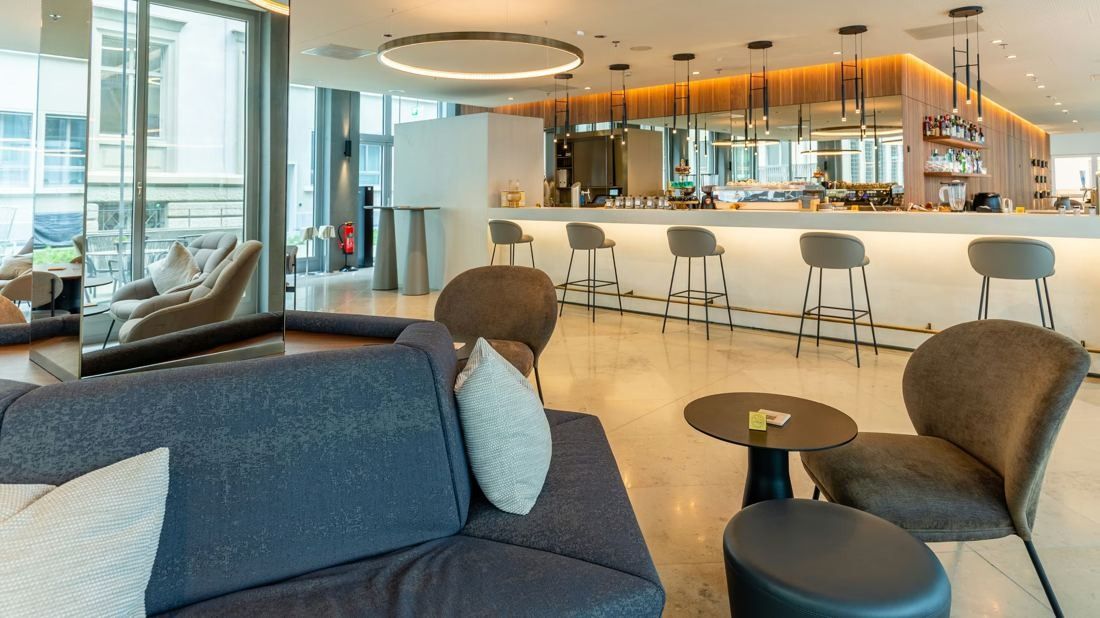 Zurich Insurance Group: Bar counter with stools, sofas and small tables under a circular light