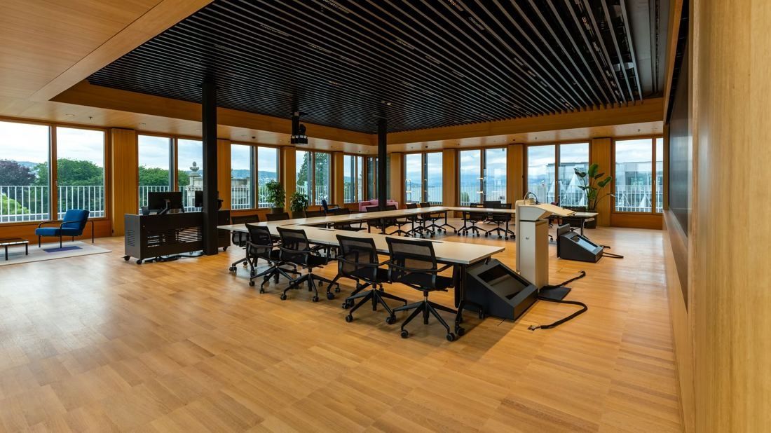 Zurich Insurance Group: Large wood-panelled room with long tables in a U shape, black chairs and windows on three sides